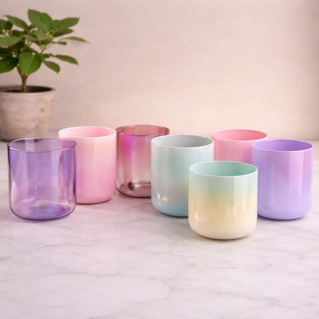 Set of colorful gradient tumblers on a light surface with a plant in the background